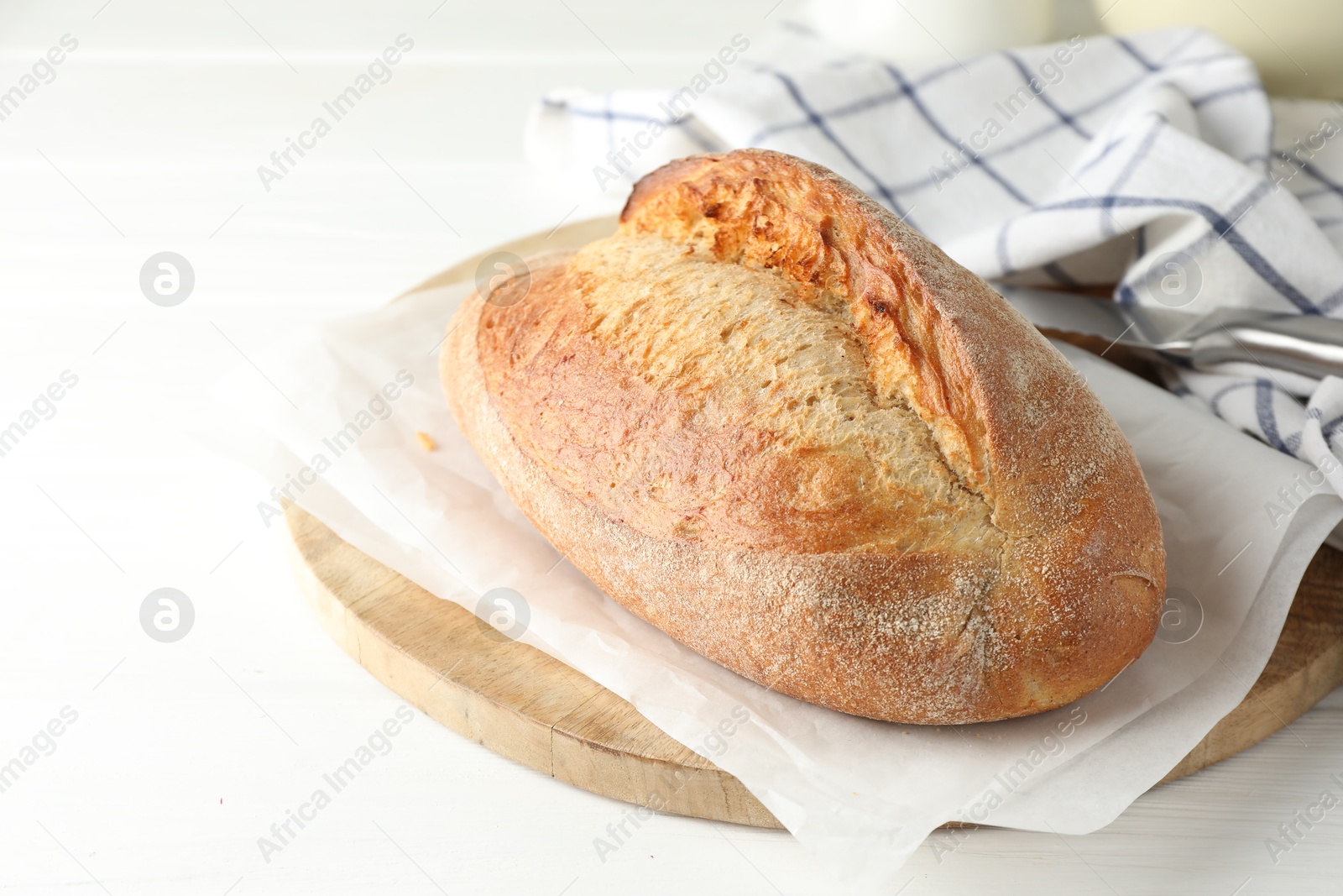 Photo of Loaf of delicious bread on white wooden table, closeup