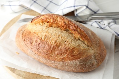 Photo of Loaf of delicious bread on white wooden table, closeup