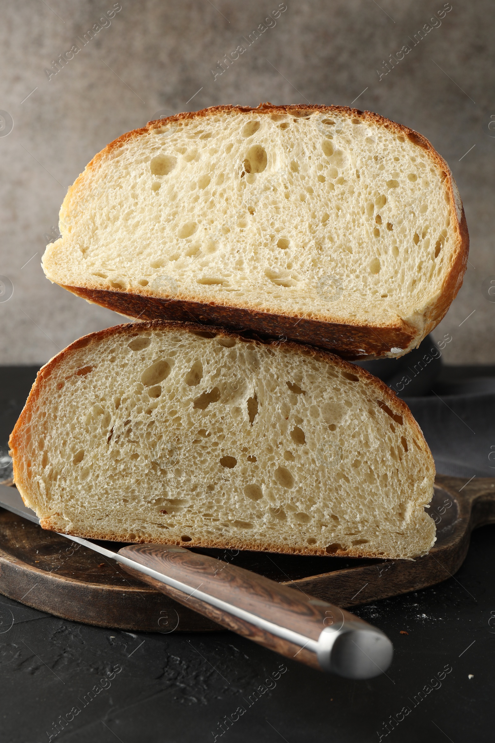 Photo of Pieces of fresh bread on black table, closeup