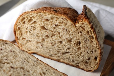 Photo of Cut loaf of fresh bread on table, closeup