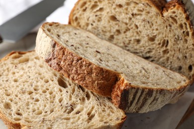 Photo of Cut loaf of fresh bread on table, closeup