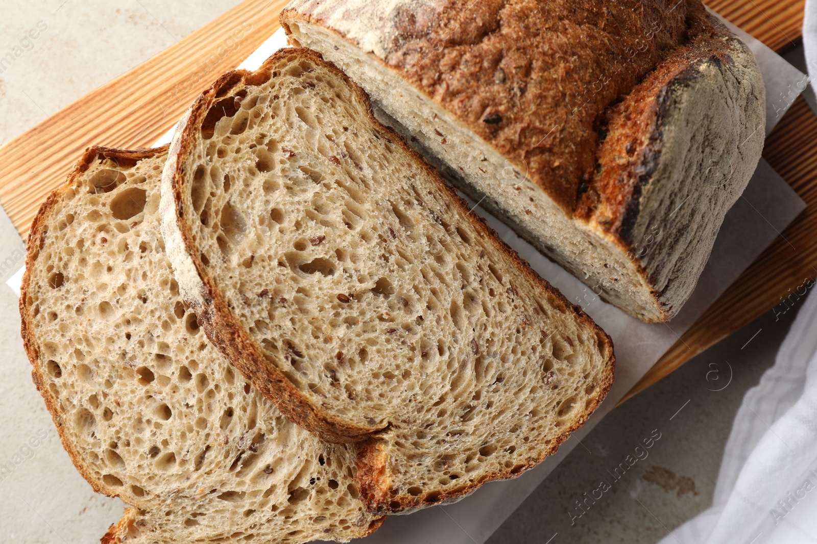 Photo of Cut loaf of fresh bread on table, closeup