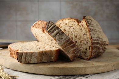 Photo of Cut loaf of fresh bread on table, closeup