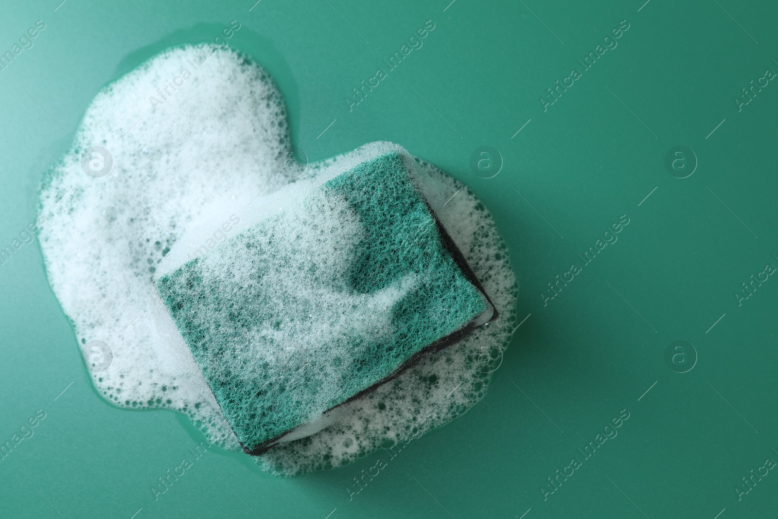 Photo of One sponge with foam on green background, top view. Space for text