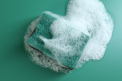 Photo of One sponge with foam on green background, top view