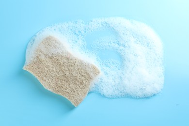 Photo of One sponge with foam on light blue background, top view