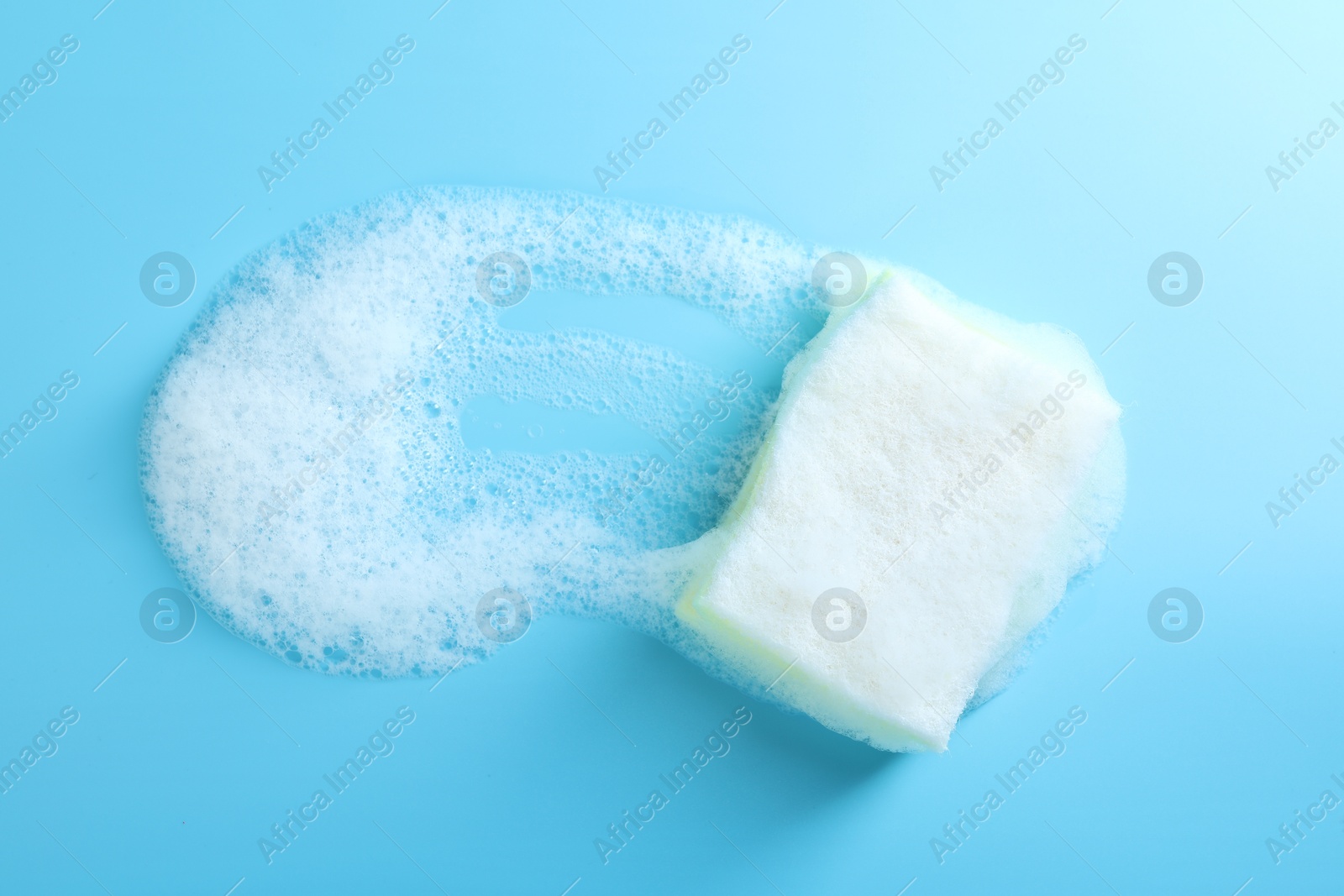 Photo of One sponge with foam on light blue background, top view