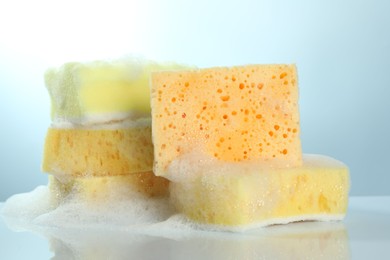 Photo of Sponges with foam on light table, closeup