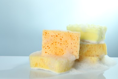 Photo of Sponges with foam on light table, closeup. Space for text