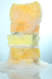 Photo of Stack of sponges with foam on light table, closeup