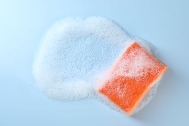 Photo of One sponge with foam on light blue background, top view