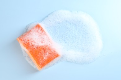 Photo of One sponge with foam on light blue background, top view