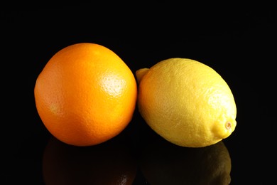 Photo of Fresh orange and lemon on black mirror surface, closeup