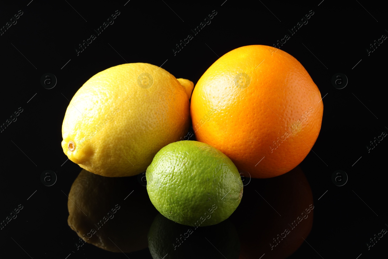 Photo of Fresh orange, lemon and lime on black mirror surface, closeup