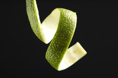 Photo of Fresh lime peel on black background, closeup