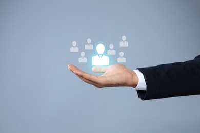 Image of Human resource. Businessman choosing one virtual figure among others on grey background, closeup