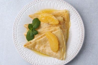 Photo of Delicious Crepes Suzette on light table, top view