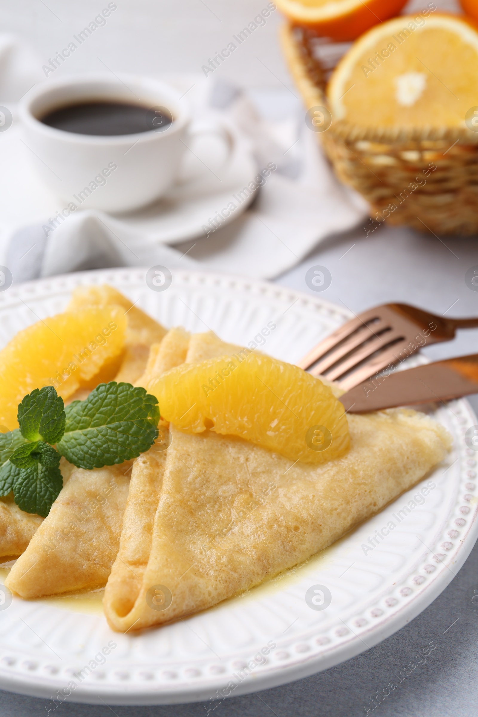 Photo of Delicious Crepes Suzette served on light table, closeup