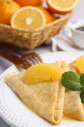 Photo of Delicious Crepes Suzette served on light table, closeup