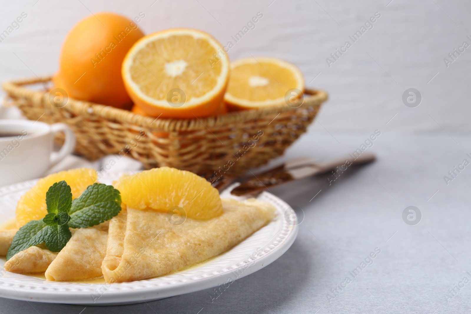 Photo of Delicious Crepes Suzette served on light table, closeup. Space for text