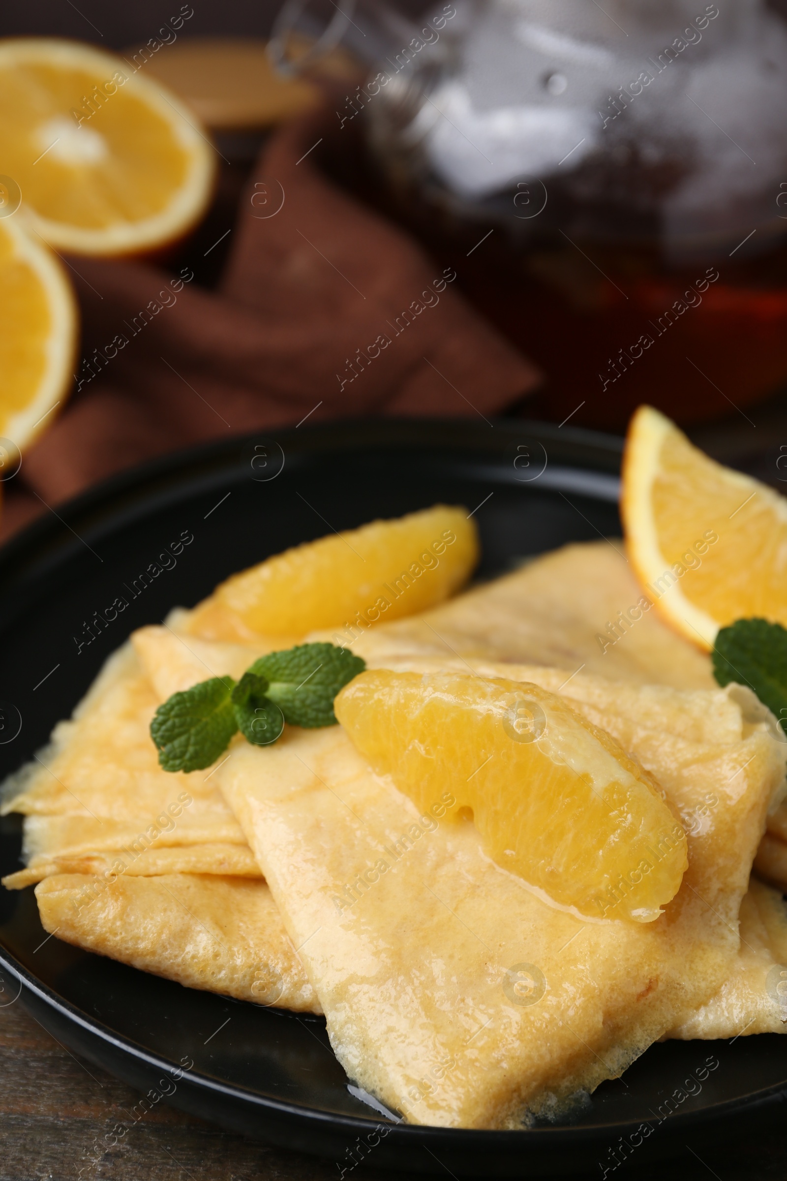 Photo of Delicious Crepes Suzette on wooden table, closeup