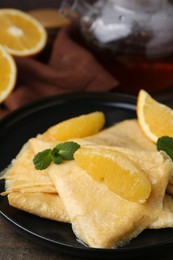 Photo of Delicious Crepes Suzette on wooden table, closeup