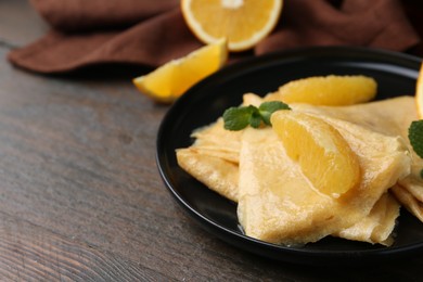 Photo of Delicious Crepes Suzette on wooden table, closeup. Space for text