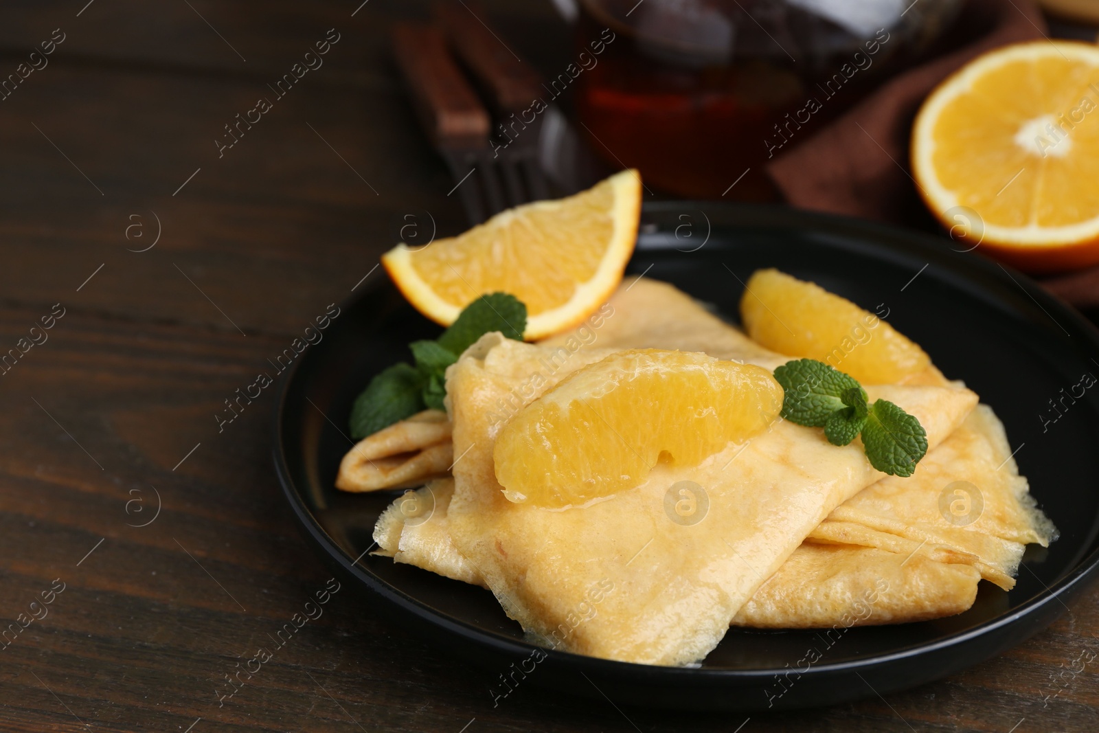 Photo of Delicious Crepes Suzette on wooden table, closeup