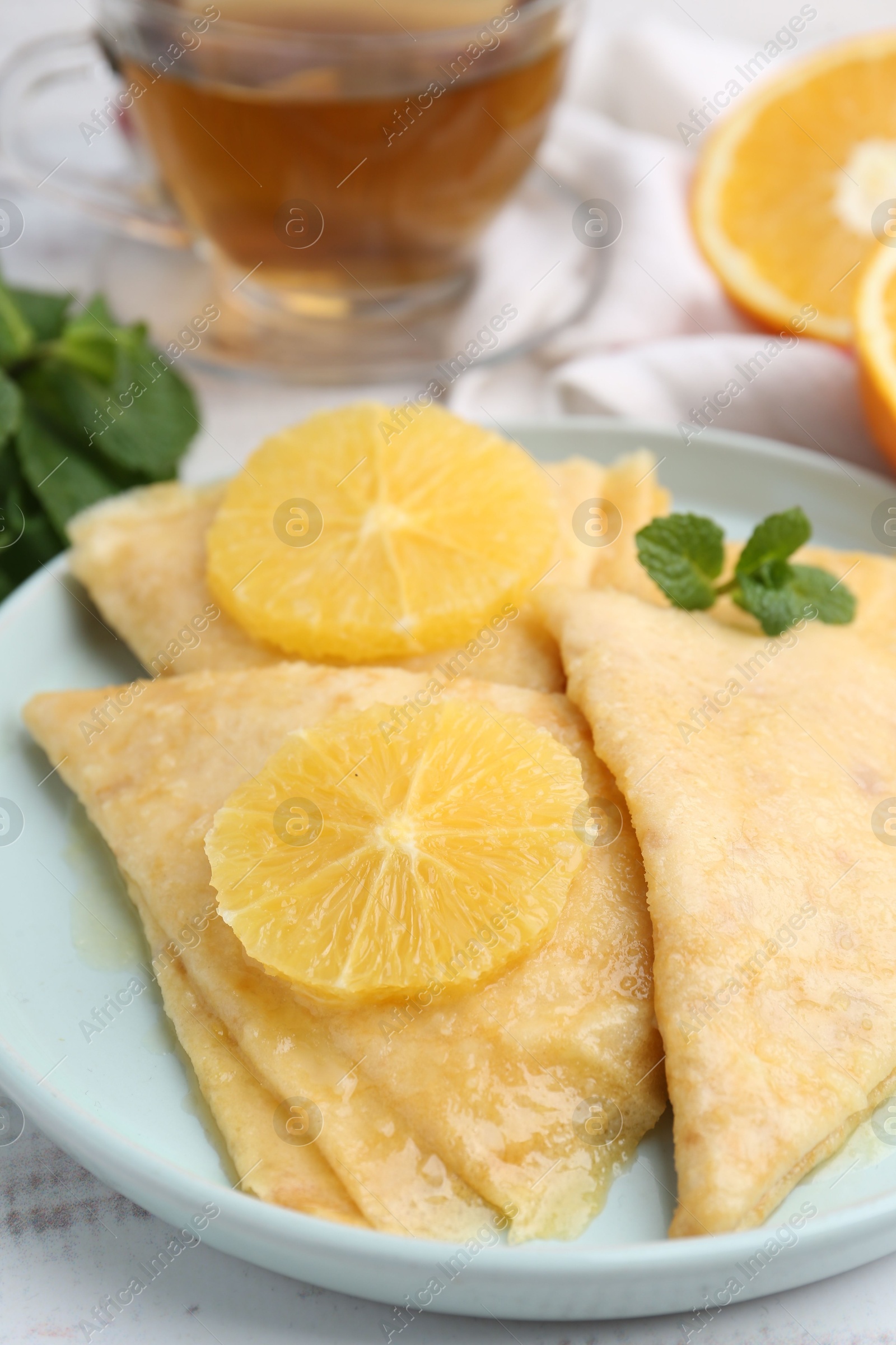 Photo of Delicious Crepes Suzette on white wooden table, closeup