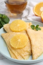 Photo of Delicious Crepes Suzette on white wooden table, closeup