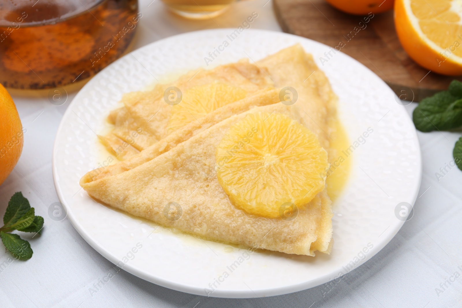 Photo of Delicious Crepes Suzette on white table, closeup