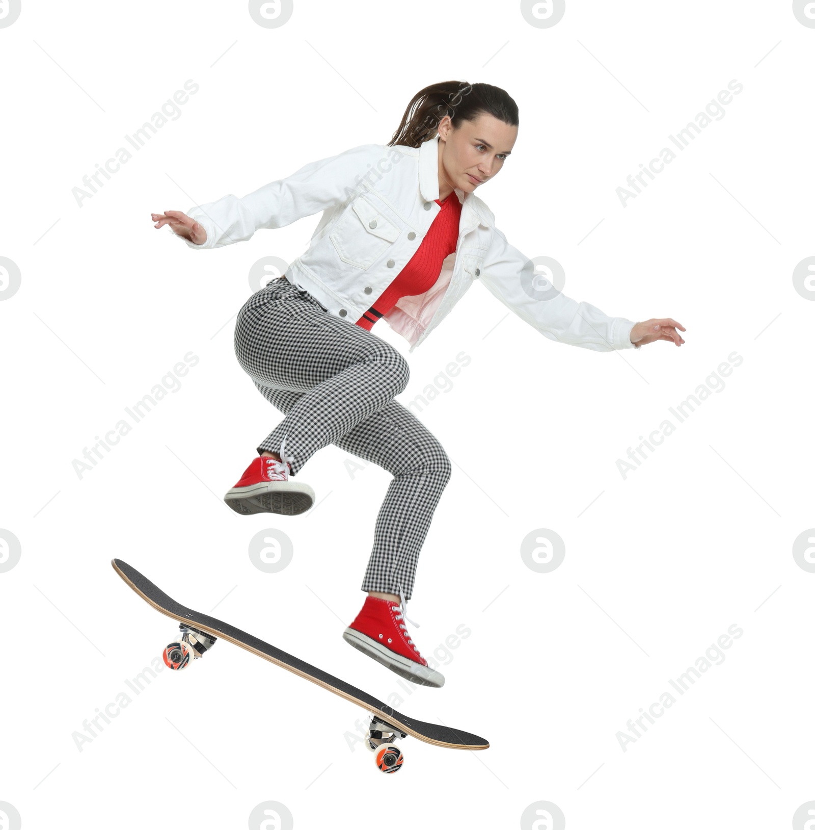 Image of Beautiful woman with skateboard in air on white background. Performing trick