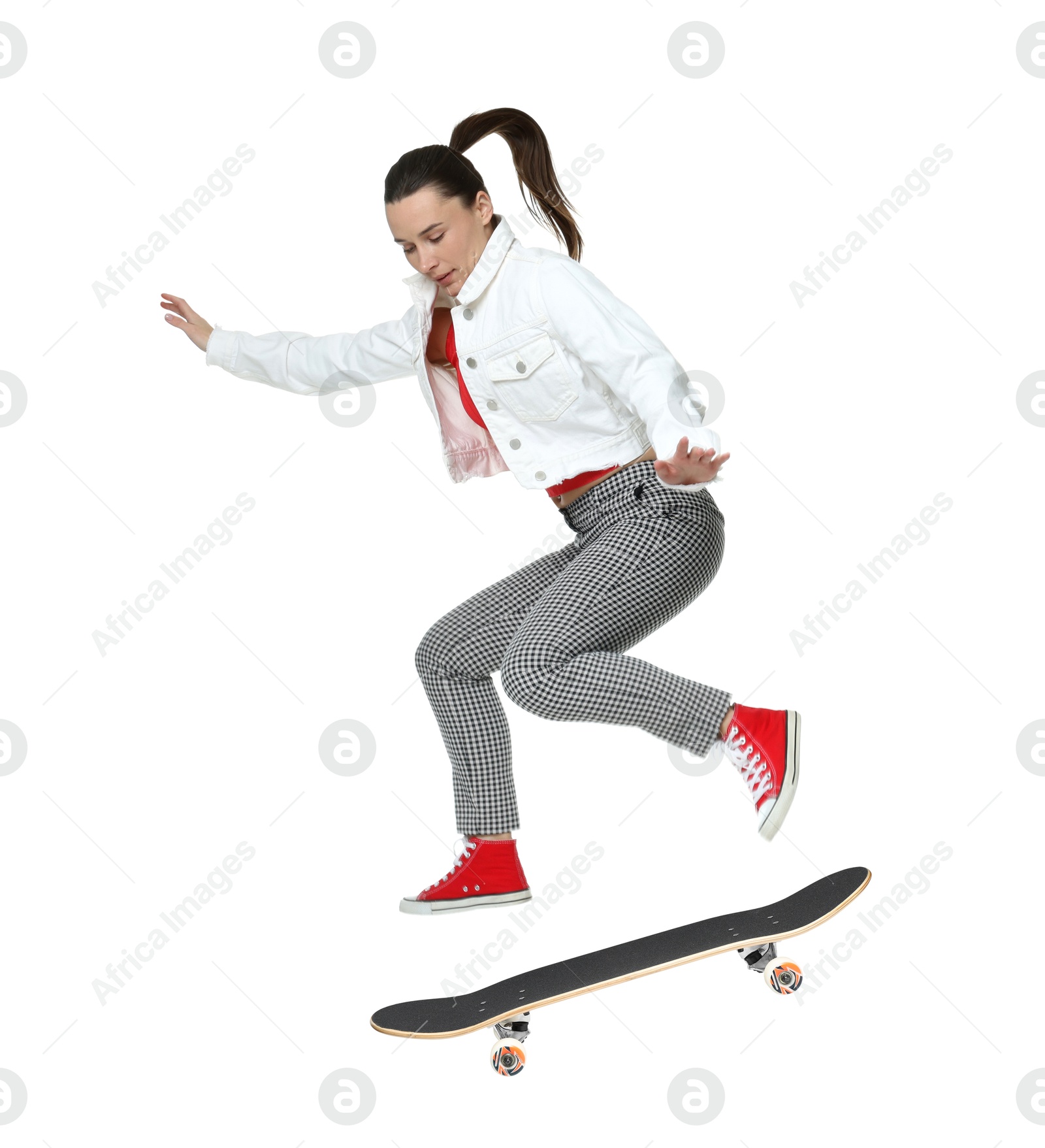 Image of Beautiful woman with skateboard in air on white background. Performing trick