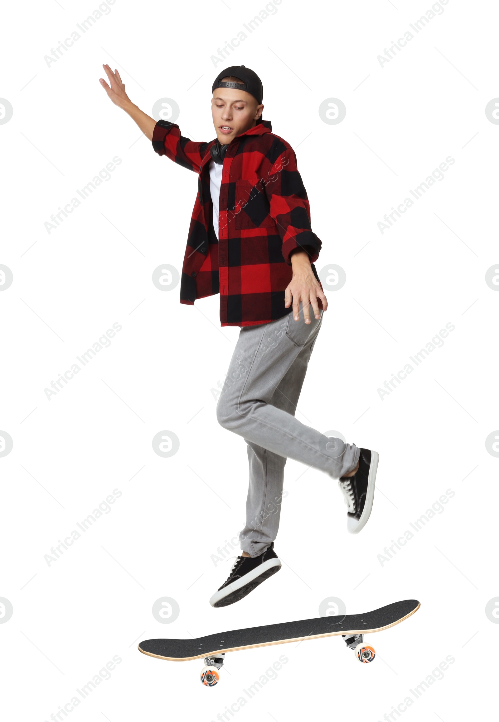 Image of Handsome man with skateboard in air on white background. Performing trick