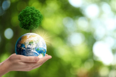 Image of Save Earth. Woman holding globe with tree outdoors, closeup