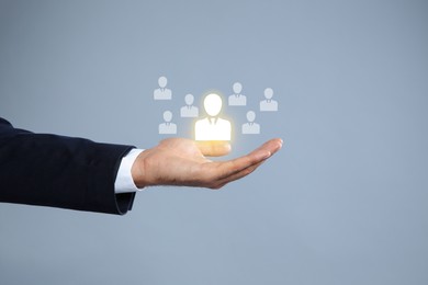 Image of Human resource. Businessman choosing one virtual figure among others on grey background, closeup