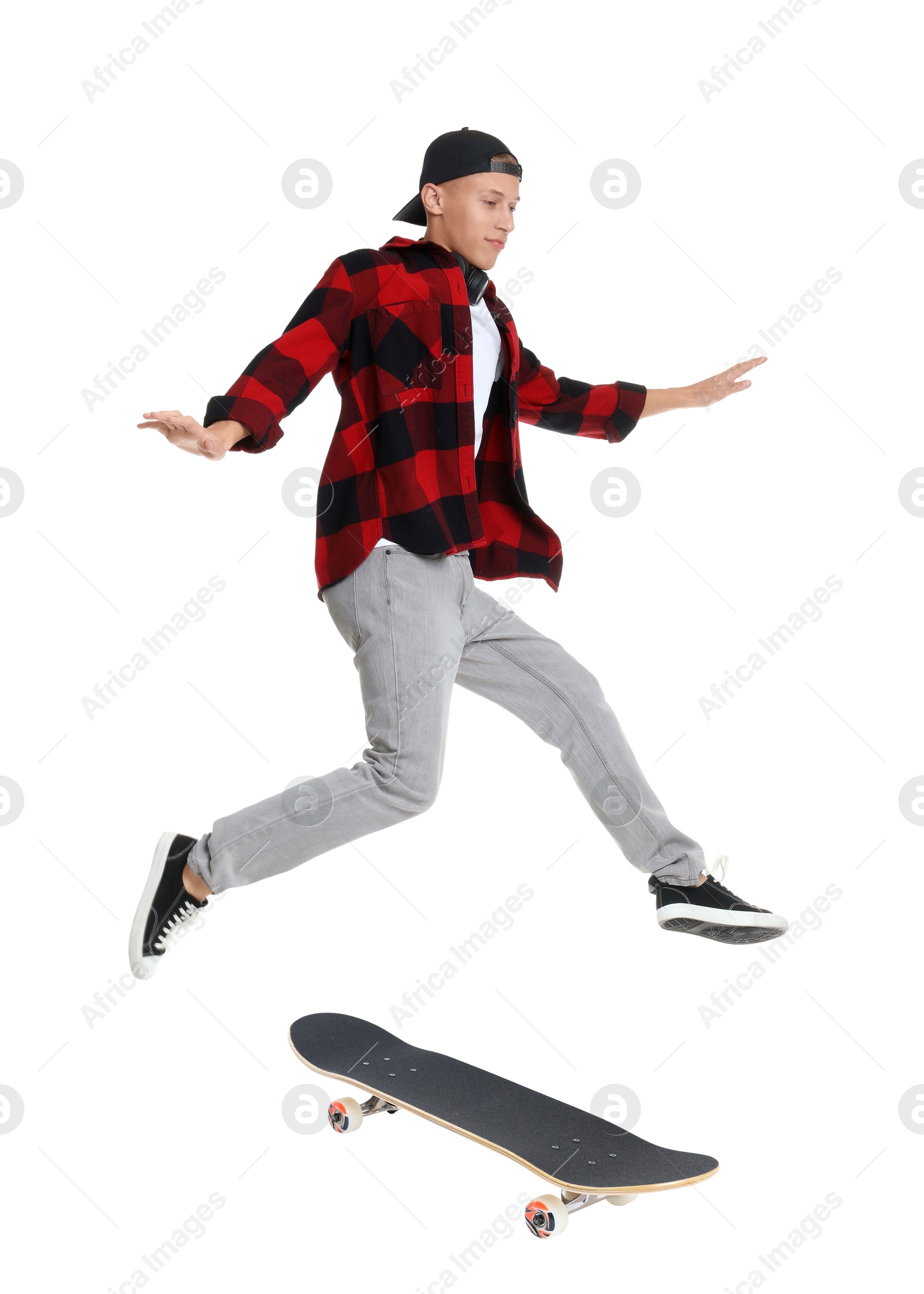 Image of Handsome man with skateboard in air on white background. Performing trick