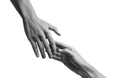 Man giving helping hand to friend on white background, closeup. Toned in black and white