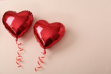 Photo of Red heart shaped balloons on beige background, flat lay with space for text. Saint Valentine's day celebration