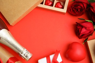 Photo of Flat lay composition with heart shaped chocolate candies on red background, space for text. Valentine's day celebration