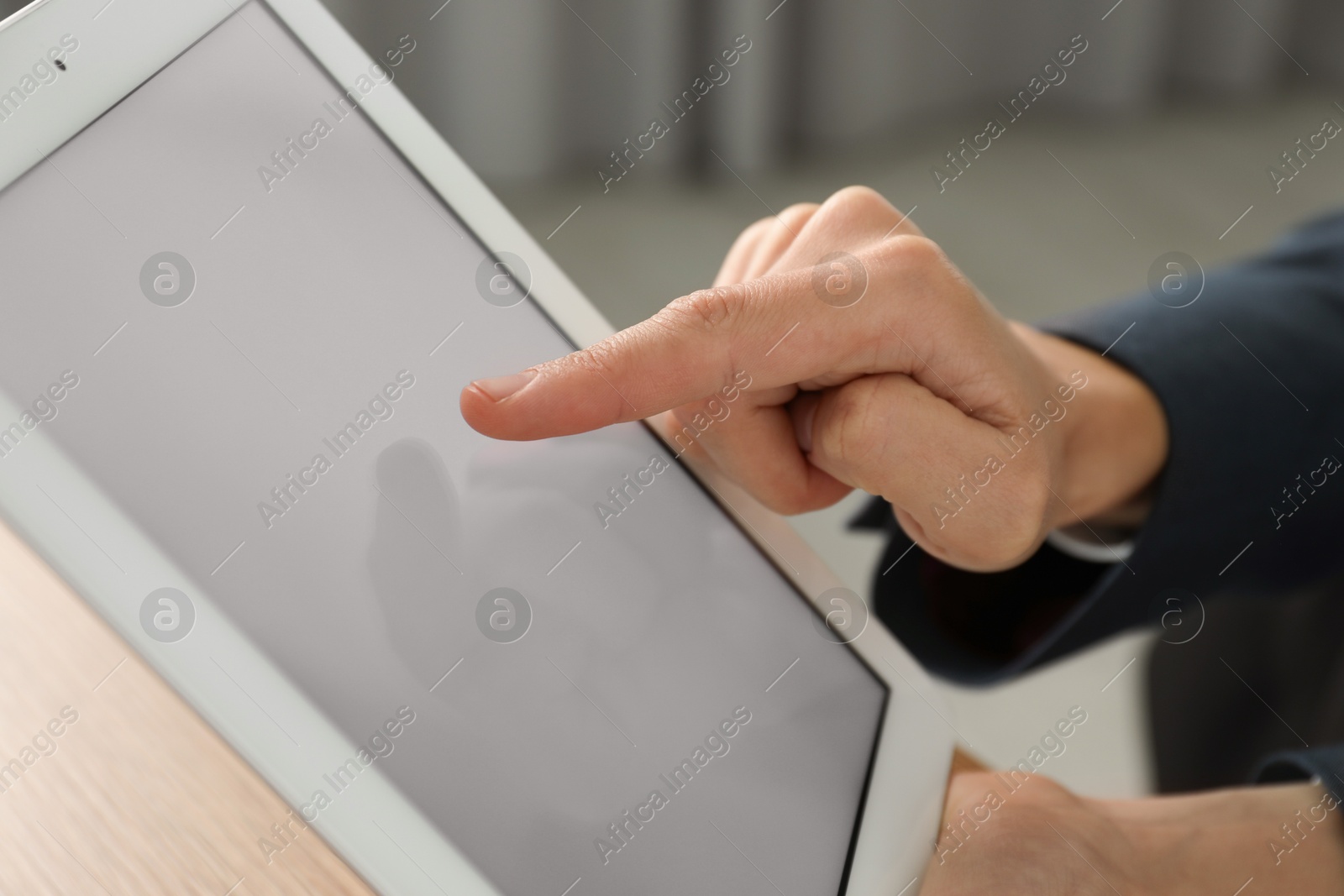 Photo of Businesswoman using tablet at table indoors, closeup. Modern technology