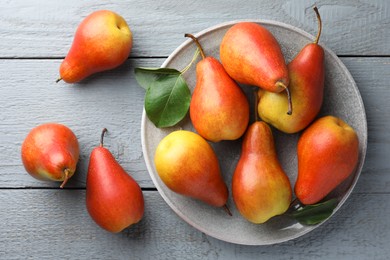 Photo of Ripe juicy pears on grey wooden table, flat lay