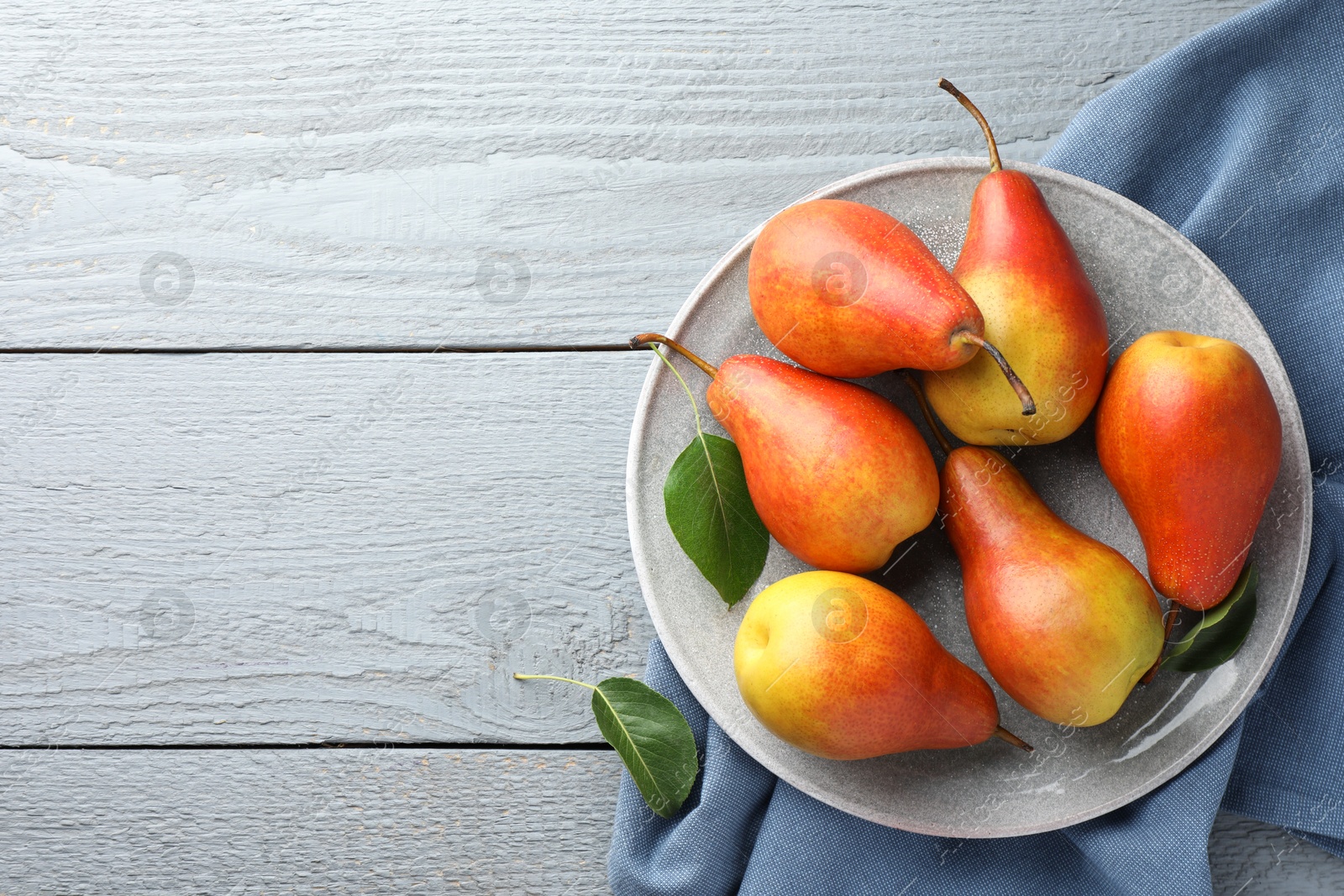 Photo of Ripe juicy pears on grey wooden table, top view. Space for text