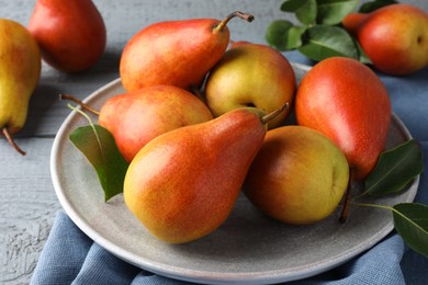 Photo of Ripe juicy pears on grey wooden table, closeup