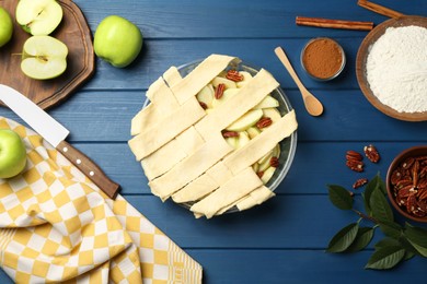 Photo of Flat lay composition with raw homemade apple pie and ingredients on blue wooden table