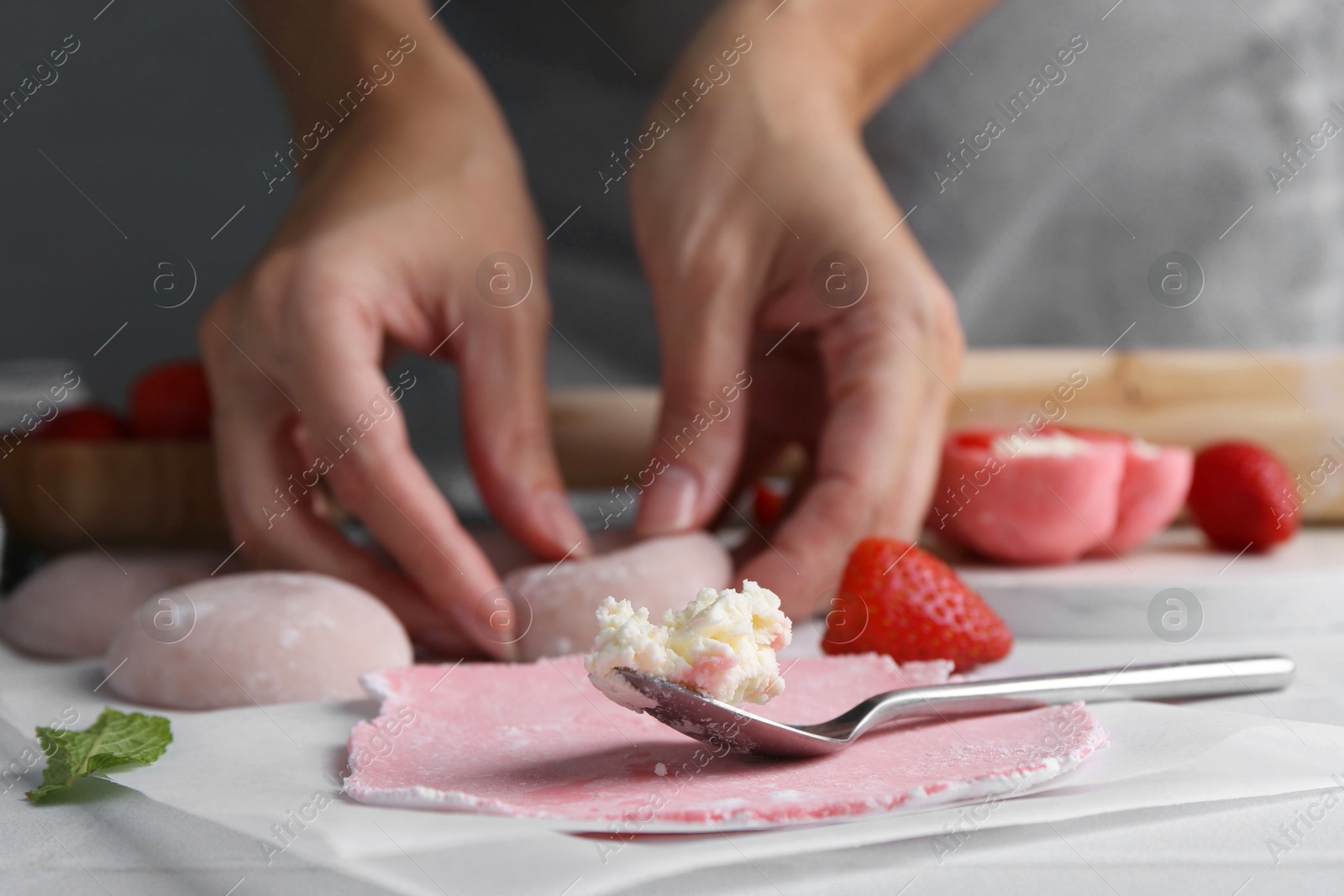 Photo of Woman making tasty mochi at table, closeup