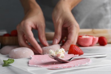 Woman making tasty mochi at table, closeup