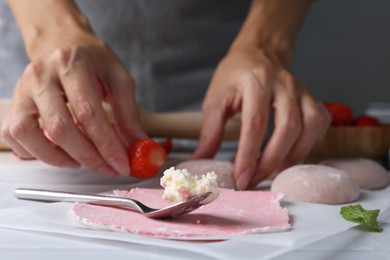 Photo of Woman making tasty mochi at table, closeup