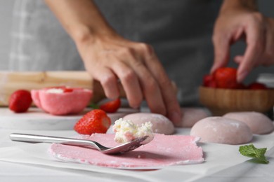 Photo of Woman making tasty mochi at table, closeup