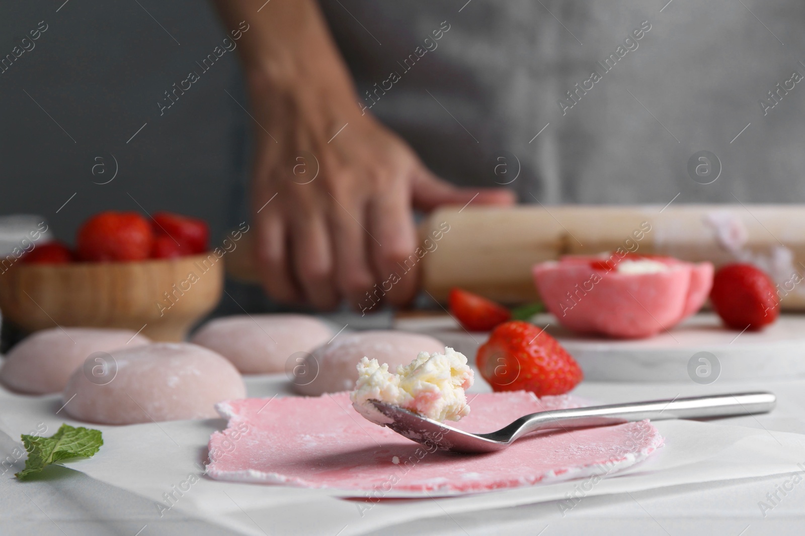 Photo of Woman making tasty mochi at table, closeup